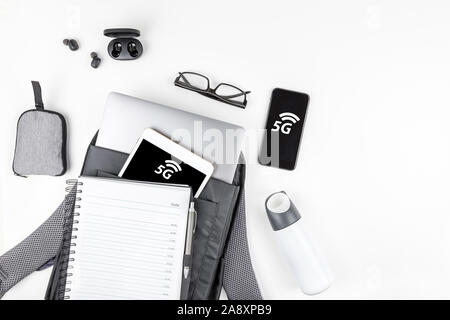 5G network, high-speed mobile Internet, new generation networks concept. Creative top view flat lay of open backpack with laptop and tablet inside, sm Stock Photo