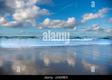 Cloudscape and seascape with waves washing onto sandy beach Stock Photo