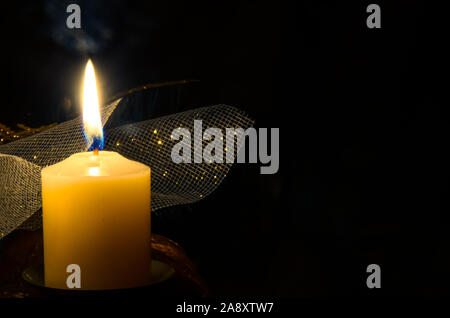 one burning festive candle against black background Stock Photo