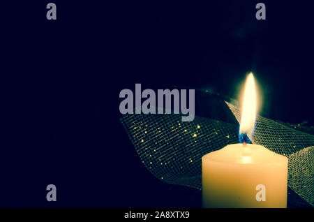 one burning festive candle against black background Stock Photo