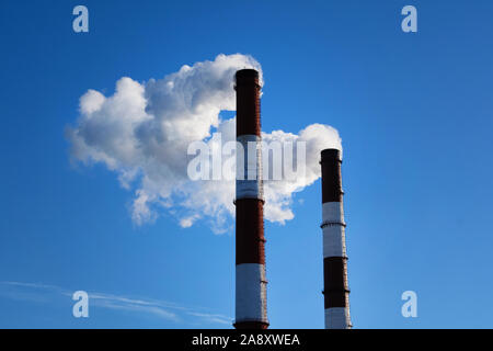 Industrial landscape of the city with smoke emissions from chimneys. Pollution. Pipes in the city with smoke. Stock Photo