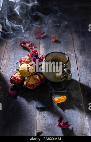 coffee in smoke and vintage dried roses beautiful food and drinks Stock Photo