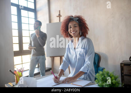 Interior designer wearing stylish head band feeling happy Stock Photo