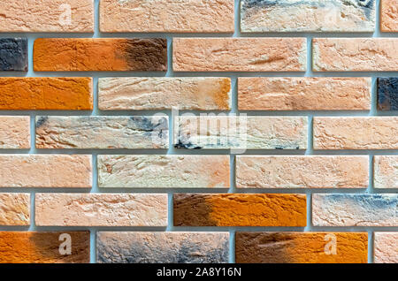 Brick wall of multicolored bricks. Background and texture of brickwork. Stock Photo