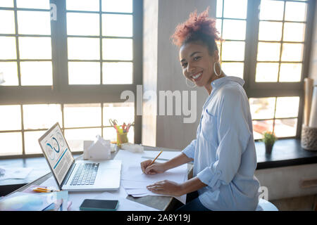 Beaming designer feeling joyful while working hard Stock Photo