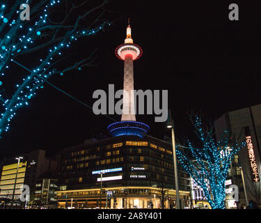 KYOTO, JAPAN, 14TH JANUARY 2019: A view of the Kyoto Tower at night from the ground level. Lighting can be seen on the tower. Stock Photo