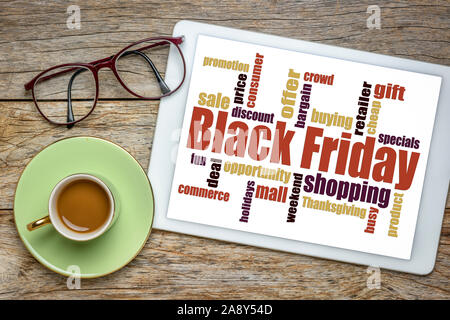 Black Friday word cloud - holiday shopping concept on a digital tablet with a cup of coffee Stock Photo