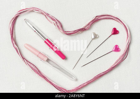 White canvas background with sewing tools and colorful threads. Embroidery concept. Mockup for hobby. Stock Photo