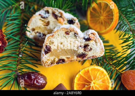 Christmas stollen with baked apple on yellow napkin with fir branches and decorations Stock Photo