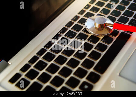 Expert examines a laptop to repair it from virus infection by internet. Stock Photo