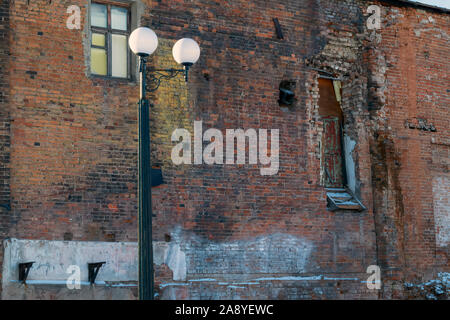 Detail of an old crumbling red brick building close-up. Old broken wall with bricks texture. Stock Photo