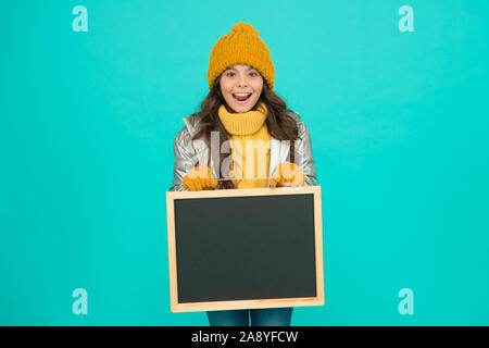 Fresh information. Schedule and working hours. Open hours. Winter entertainment and activities. Happy hours. Promotion concept. Smiling girl wear winter outfit show blank chalkboard copy space. Stock Photo