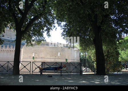 Man resting on bench near Ponte Sant Angelo Stock Photo