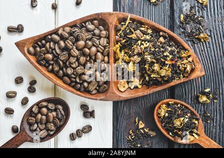 Coffee versus tea. Interesting concept with coffee and tea on black and white wood. Stock Photo
