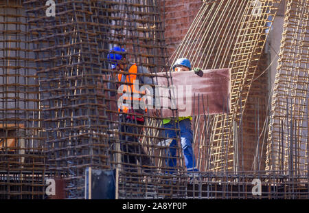 Bucharest, Romania - November 11, 2019: Two construction workers prepare pillars for pouring concrete at a building which is in rebuilded, in Buchares Stock Photo