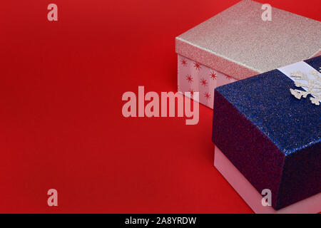Red and white gift boxes in sparkles on a red background. New year concept, top view, copy space, minimal style. Stock Photo