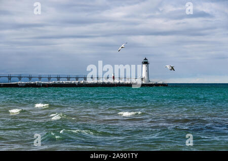 Seagulls flying near the Manistee North Pierhead on Lake Michigan in the winter Stock Photo