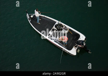 Two men fishing off a boat on the Colorado River in Austin Texas Stock Photo