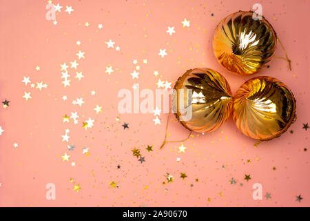 Scattered stars and Christmas tree balls on a coral color background, Christmas, New year decorations Stock Photo
