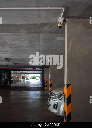 CCTV camera installed on concrete ceiling in the parking lot in condominium vertical style. Stock Photo