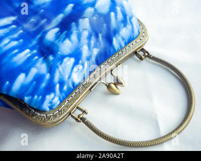 Vintage purse made by indigo blue fabric on white background. Vintage clutch retro style. Stock Photo