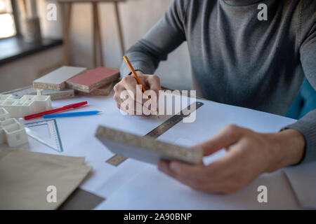 Interior designer holding pencil while making sketches Stock Photo