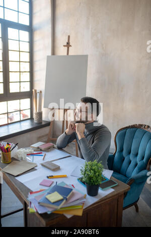 Dark-haired man enjoying little break after making sketches Stock Photo