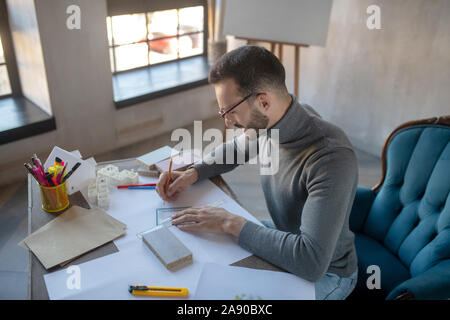 Interior designer making sketches with pencil and ruler Stock Photo