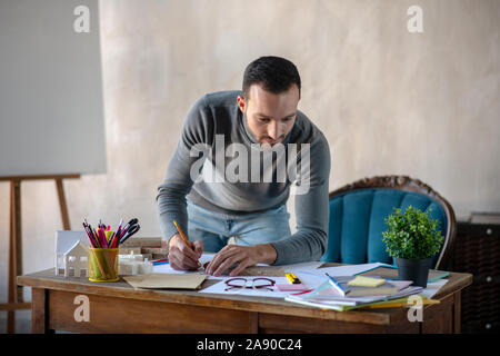 Handsome interior designer making sketches for new project Stock Photo