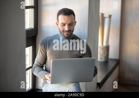 Businessman reading e-mail on laptop while working from home Stock Photo