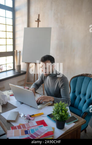 Designer smiling while reading e-mail from colleague Stock Photo