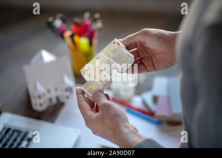 Top view of interior designer holding apartment model Stock Photo