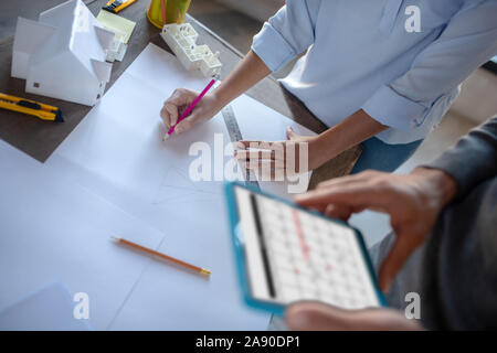 Woman making sketches standing near interior designer Stock Photo