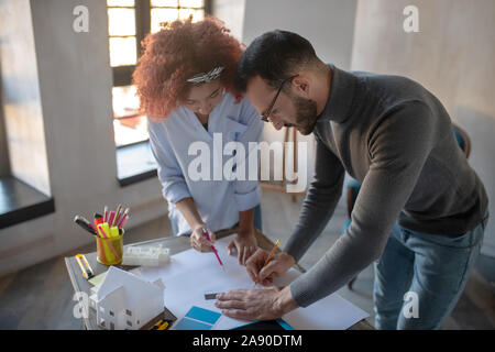 Bearded interior designer teaching assistant making sketches Stock Photo