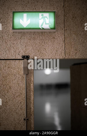 Color image of a green exit sign above a door. Stock Photo