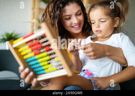 Beautiful woman and kid girl playing educational toys and having fun Stock Photo