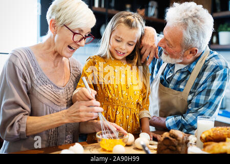 Happy grandparents having fun times with children at home Stock Photo