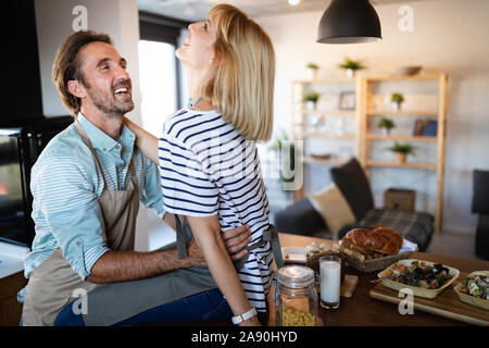 Happy young couple cooking together in the kitchen at home. Stock Photo