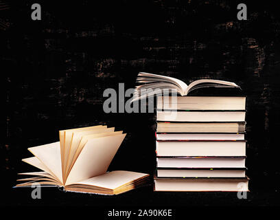 Stack of different books on dark background. Knowledge concept. Stock Photo