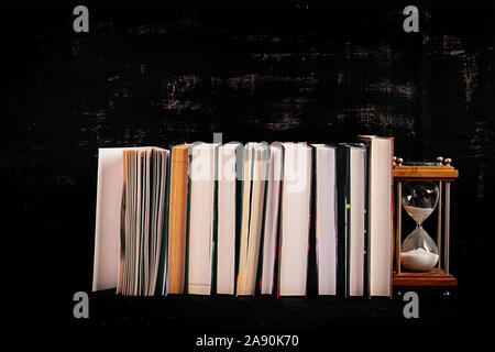 Stack of different books on dark background. Knowledge concept. Stock Photo