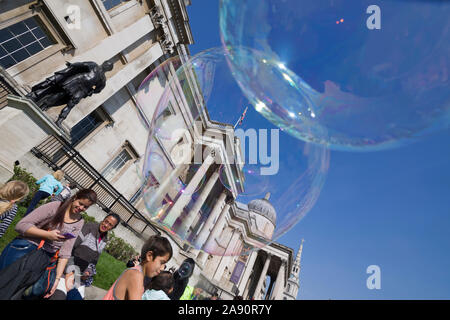 Bubbles created by a busker / street performer , in front of  The National Gallery, Trafalgar Square, London, UK Stock Photo