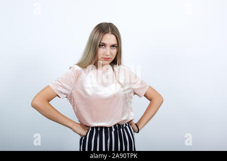 Portrait of angry pretty woman in casual clothes looking, keeps hands on belt Stock Photo