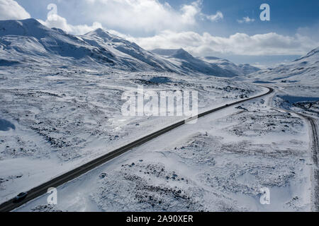 Aerial view of a winding road among the snowy mountains in the north of Iceland Stock Photo