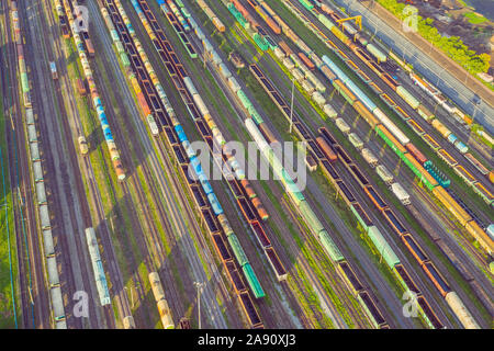 Aerial view of rail sorting freight station with railway cars, with many rail tracks railroad. Heavy industry landscape on evening sunset light Stock Photo