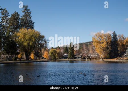 Mirror Pond surrounded by trees with fall foliage next to Drake Park in Bend, Oregon, a favorite central spot for walks and picnics in the city. Stock Photo