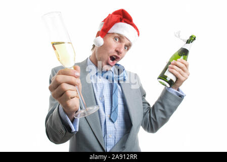 Excited office worker in Santa hat holding a bottle of bubbly and a glass out in a toast Stock Photo