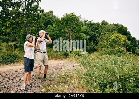 Senior couple looking through binoculars Stock Photo