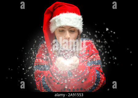 An isolated shot of a woman celebrating christmas and blowing snow Stock Photo