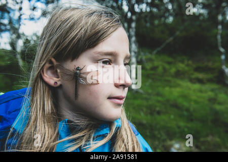 Dragonfly on girls face Stock Photo