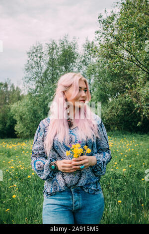 Woman holding dandelion flowers Stock Photo